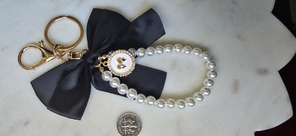Black Satin Bow Bag Charm Pearl Wristlet Keychain, product photo from Rey & Luck Co